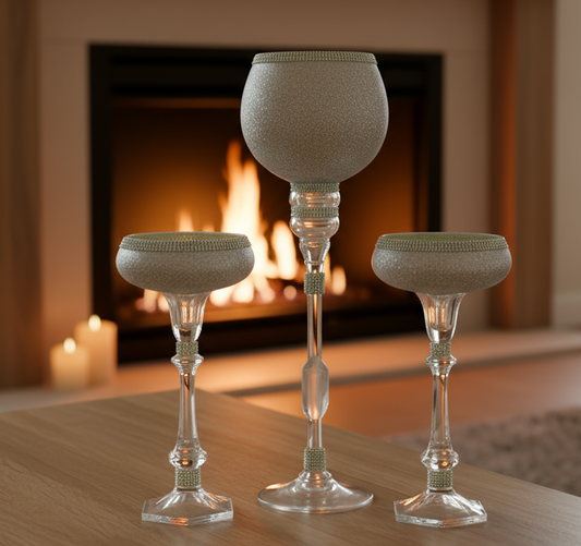 Set of three decorative glass vases on a table with a blurred indoor background