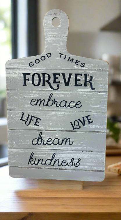 Decorative sign with motivational phrases on a wooden surface