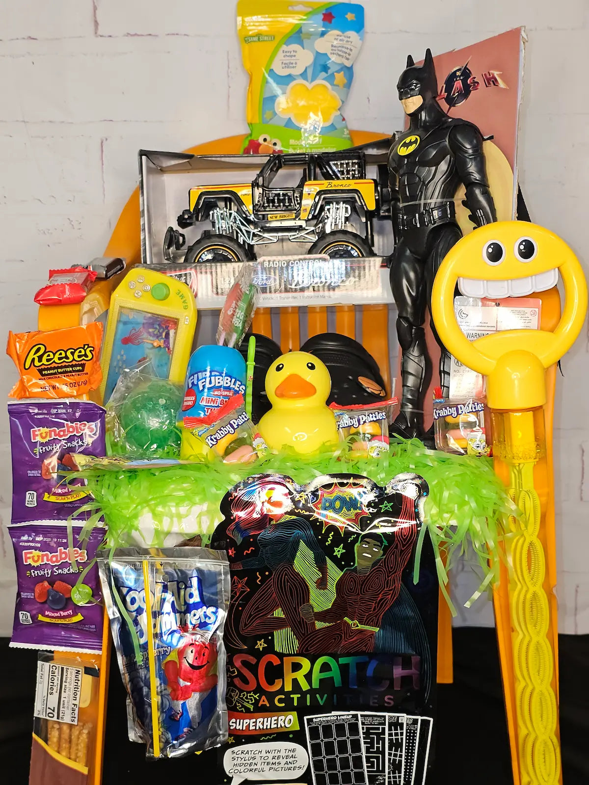 Assorted toys and snacks on a table with a white brick wall background